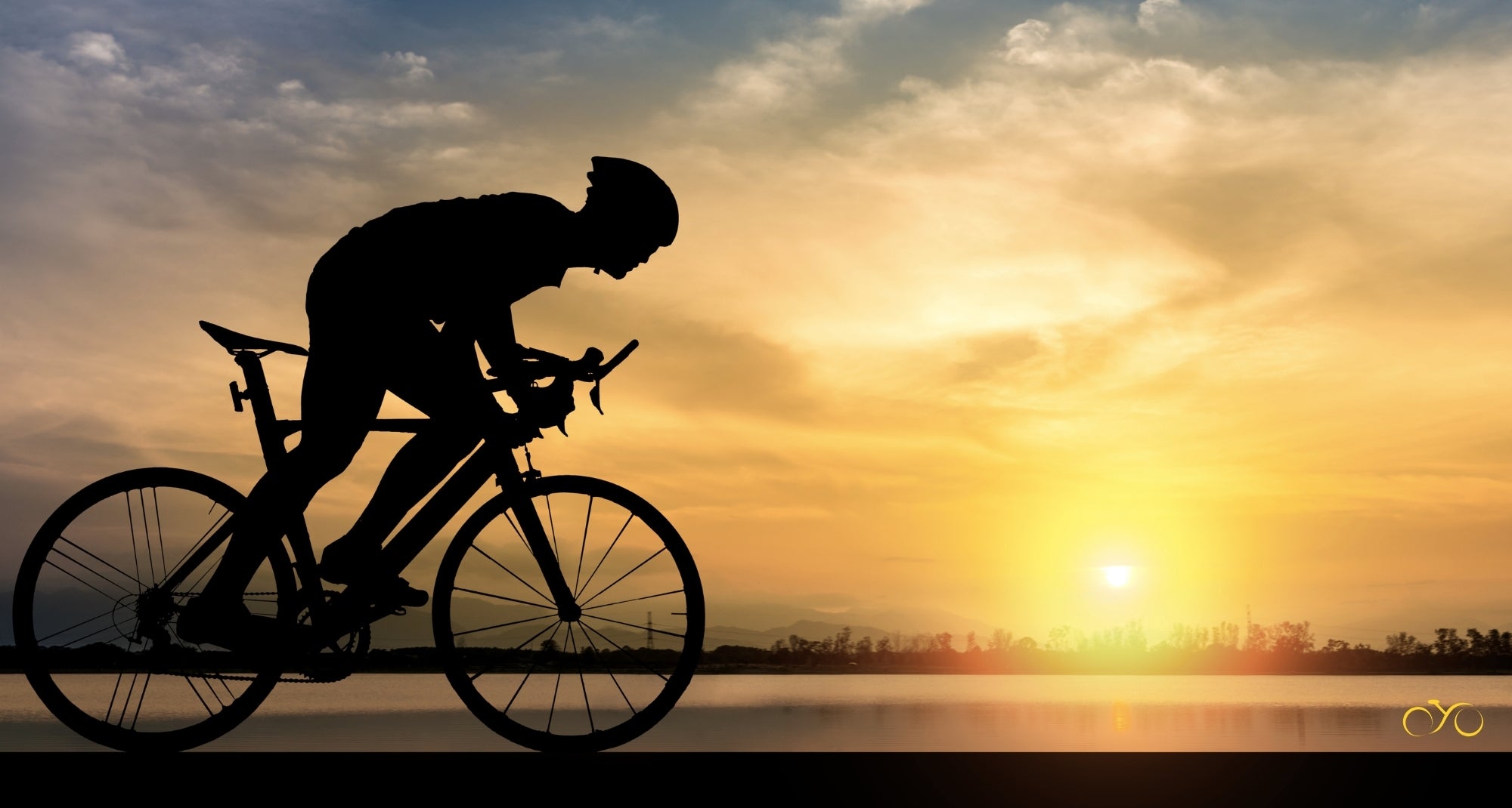 Silhouette of a cyclist against a sunset sky