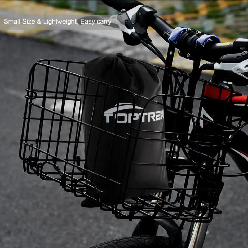 Bicycle basket with a black bag on a blurred street background.