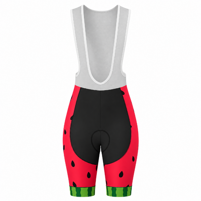 Rear view of cycling bib shorts with a watermelon print. The shorts feature a light gray bib upper section with white trim, a black center panel, and red side panels printed with black watermelon seeds and green striped rinds at the bottom.