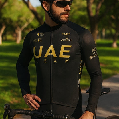 Man wearing a black cycling jersey with 'UAE Team' branding in a park setting