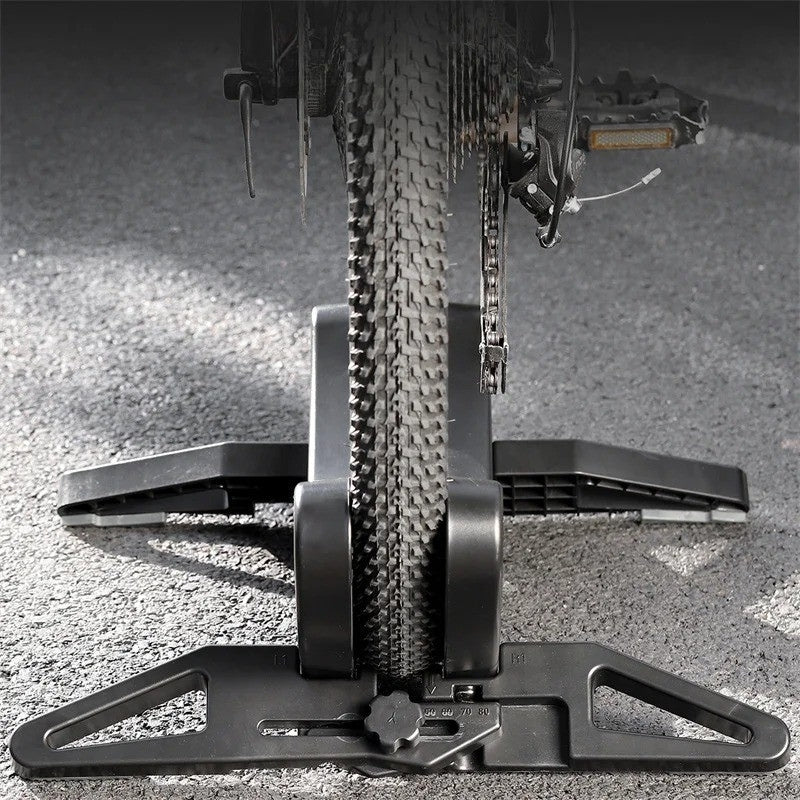 Bicycle tire on a floor stand with a close-up view of the tread pattern and chain.