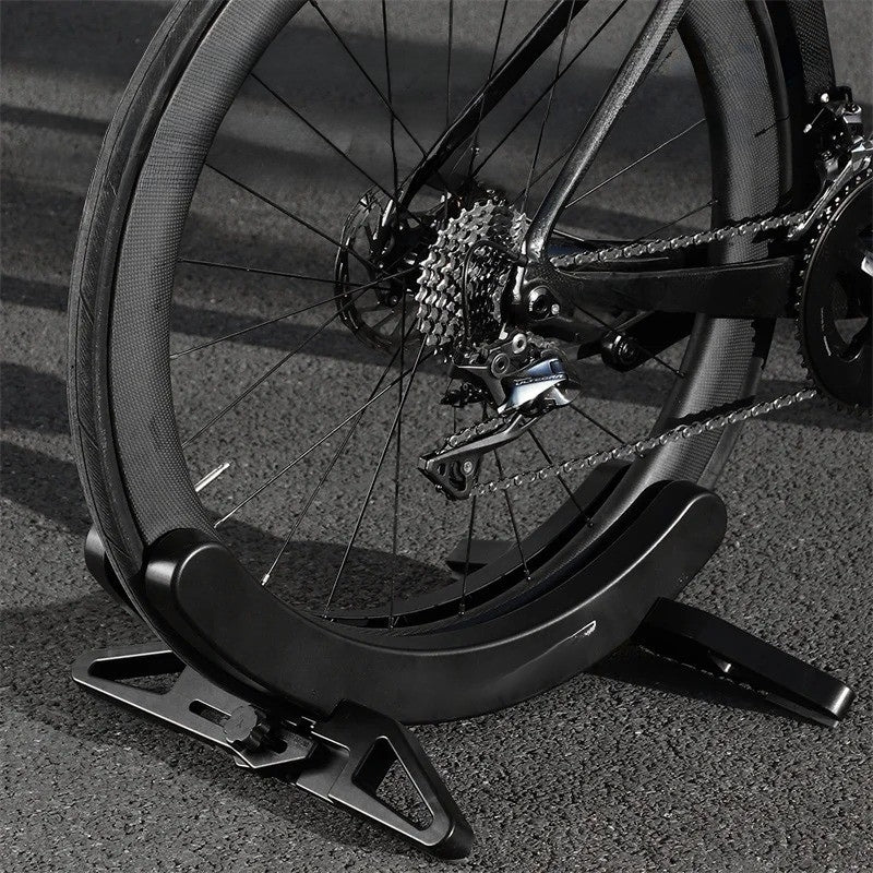 Bicycle wheel on a stand with a blurred road background