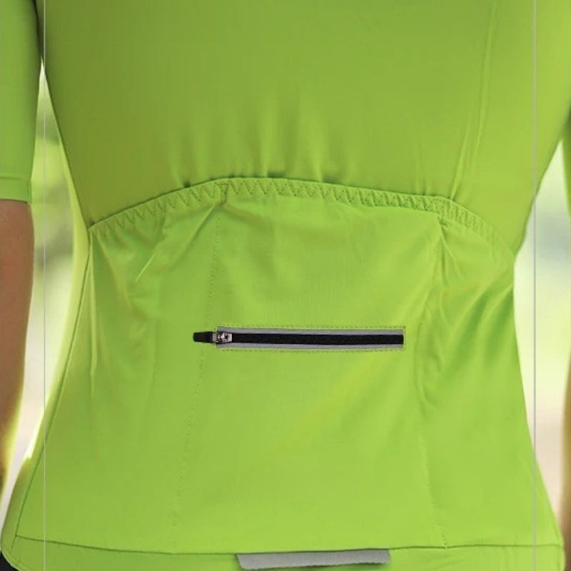 Close-up of a bright green jacket with a zipper pocket on a blurred natural background