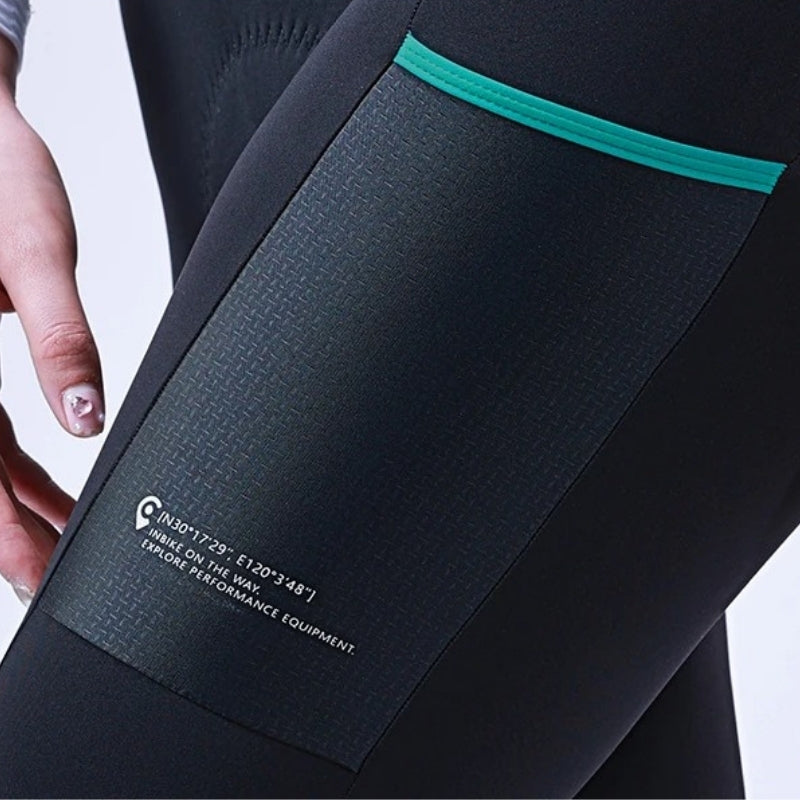 Close-up of a black athletic outfit with teal trim and a visible brand label.