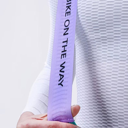Person holding a white sleeve with a purple band on a light gray background.