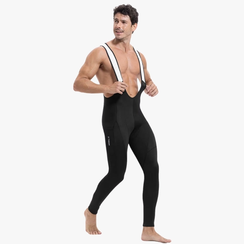 Man wearing a black wetsuit with white straps on a white background