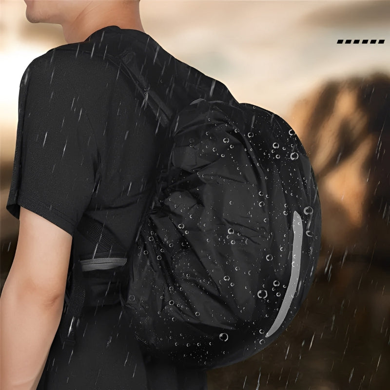 Person wearing a black backpack with raindrops on a blurred outdoor background