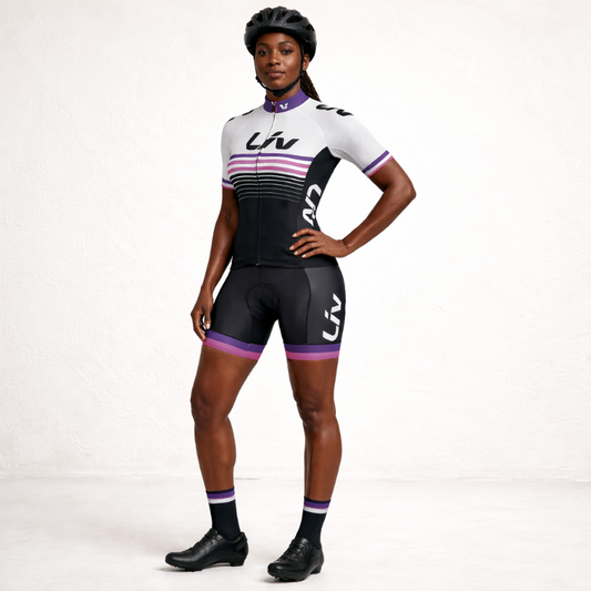Person wearing a black and white cycling outfit with purple accents on a white background