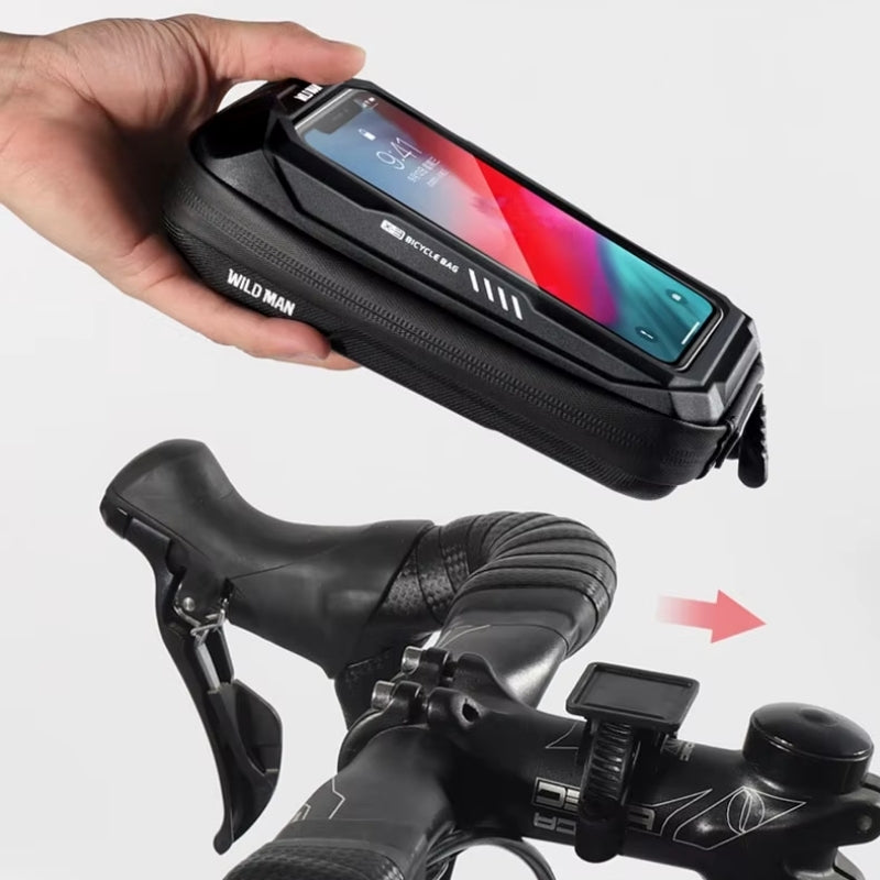 Hand holding a black phone case with 'Wild Man' branding, attached to a bicycle handlebar.