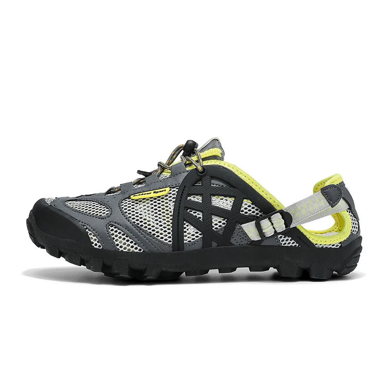 A single low-top athletic shoe shown in side profile on a white background. The shoe features a gray and black mesh upper with a prominent black side cage, a black outsole, and bright neon yellow accents on the lining, laces, and heel strap.