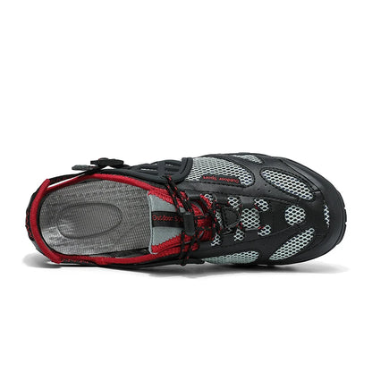 A single water shoe shown from a side profile view on a white background. The shoe features a black mesh upper with light gray synthetic overlays, black laces, and red trim along the collar and around the lace area.