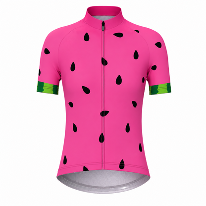 A short-sleeve cycling jersey in bright pink with a watermelon print, featuring black seed shapes and green striped cuffs, shown on a plain white background.