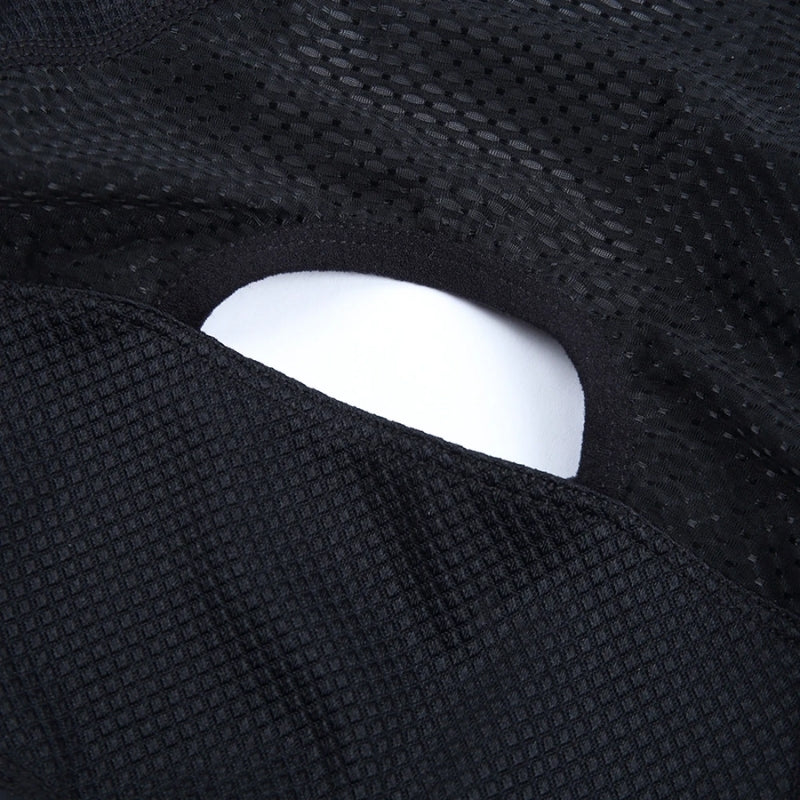 Close-up of a black textured fabric with a white object partially visible.