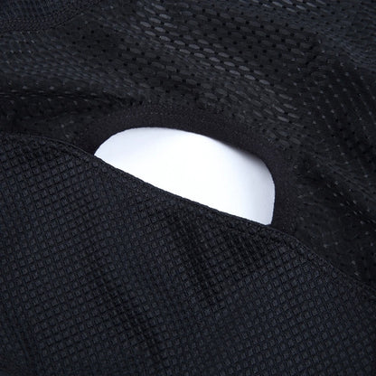 Close-up of a black textured fabric with a white object partially visible.