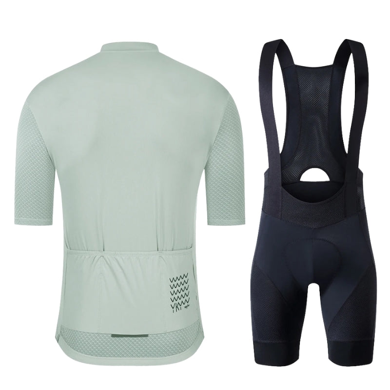 Light green cycling jersey and black bib shorts on a white background