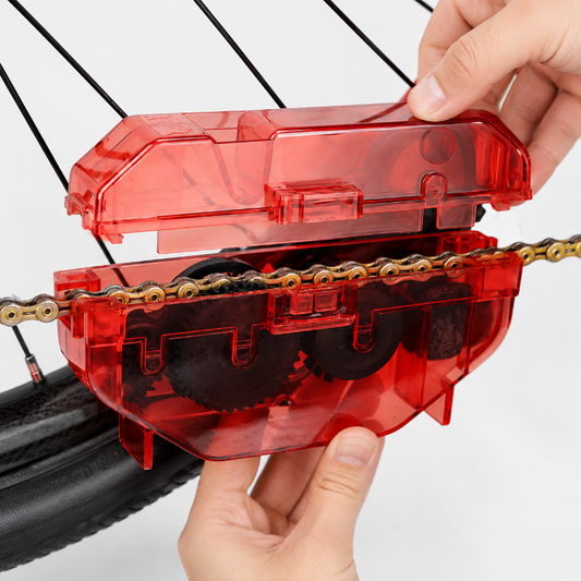 Red chain tool being used on a bicycle chain with a white background
