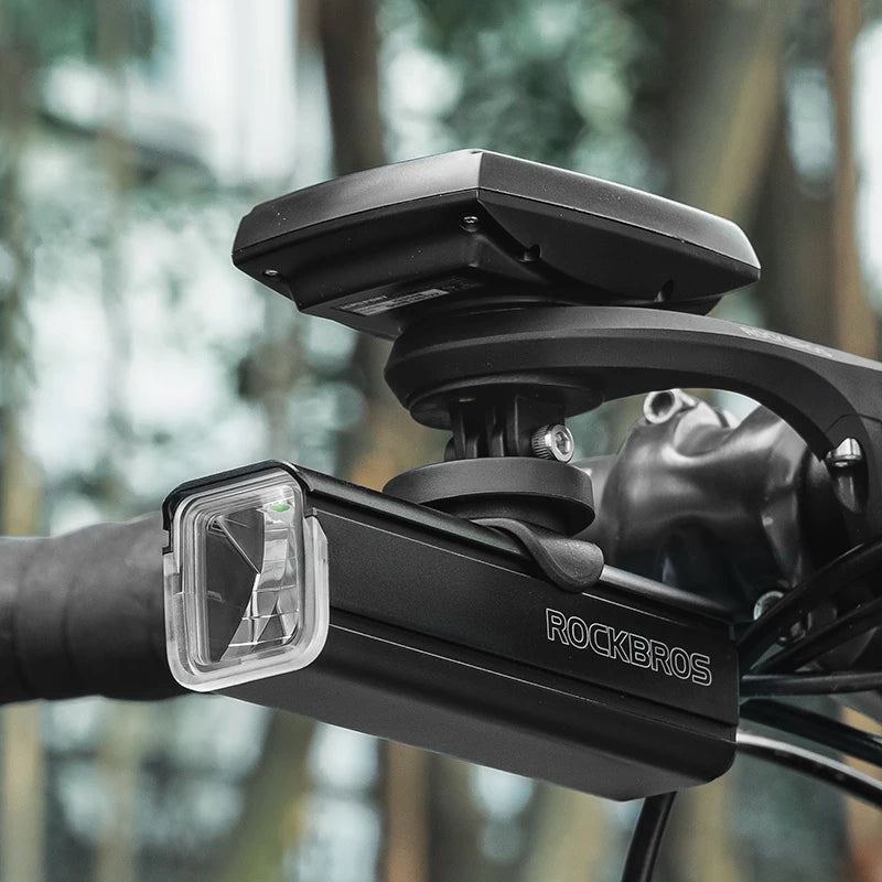 Black bike light mount with  against a blurred natural background