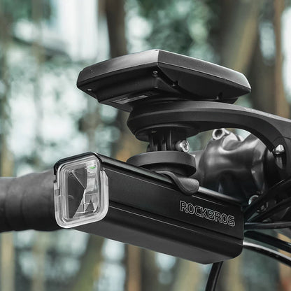 Black bike light mount with  against a blurred natural background