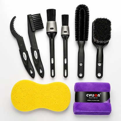Set of car cleaning tools including brushes, a sponge, and a towel on a white background