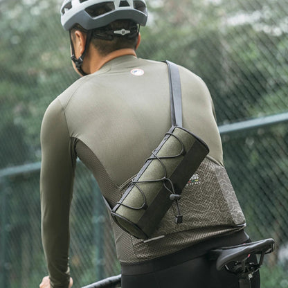 Person riding a bicycle with a bag on their shoulder, wearing a helmet and cycling outfit.