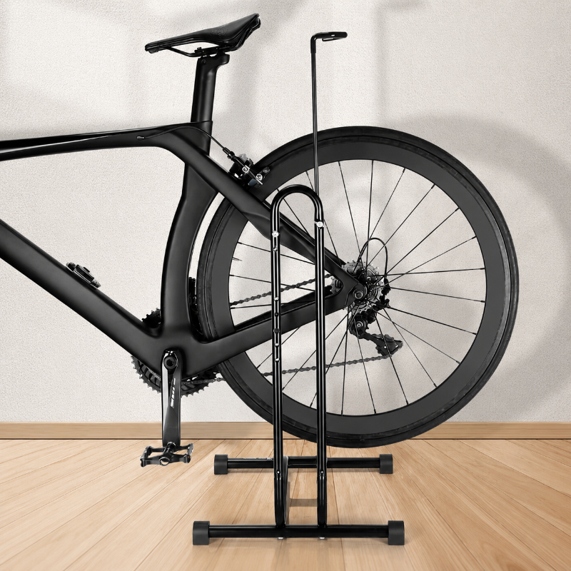 Black bicycle on a stand against a white wall