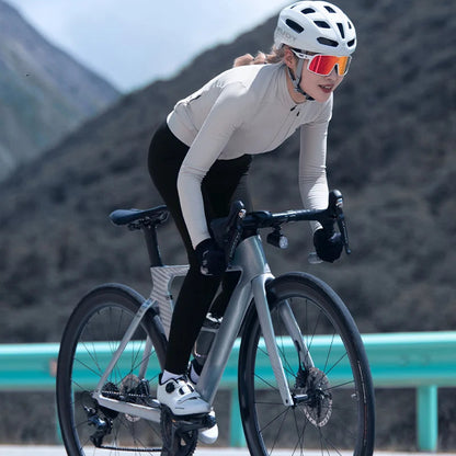 Cyclist riding on a road with mountains in the background