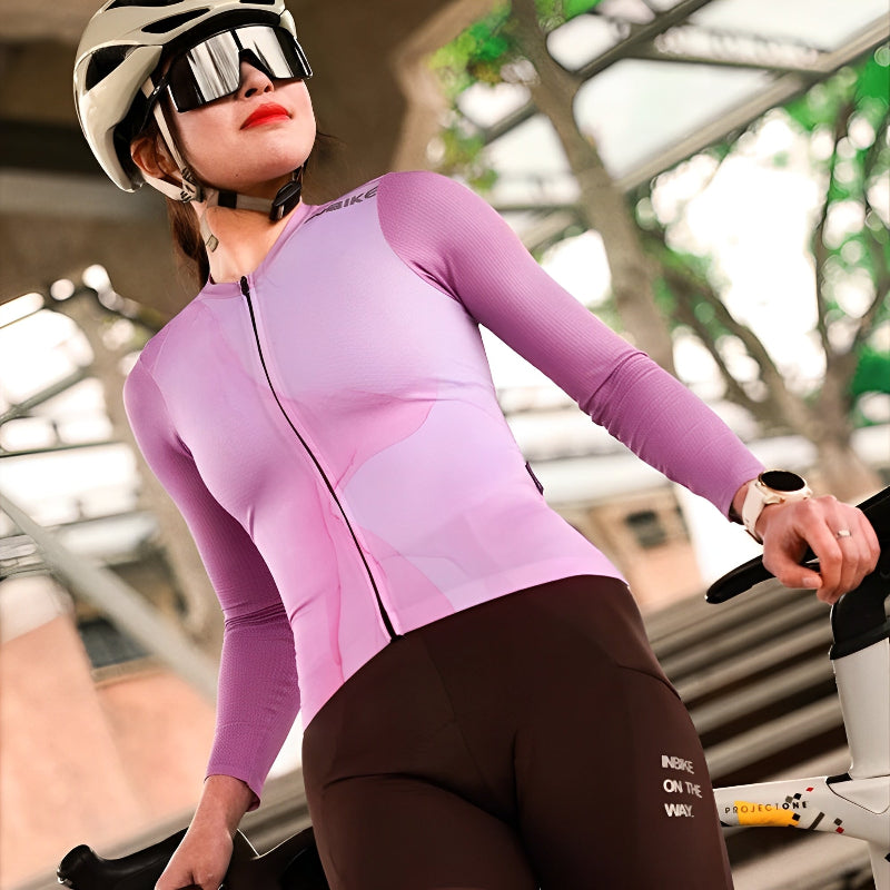 Woman riding in purple cycling jersey on mountain road