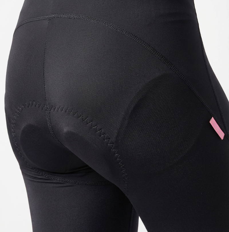 Close-up of black athletic shorts with a pink label on a white background