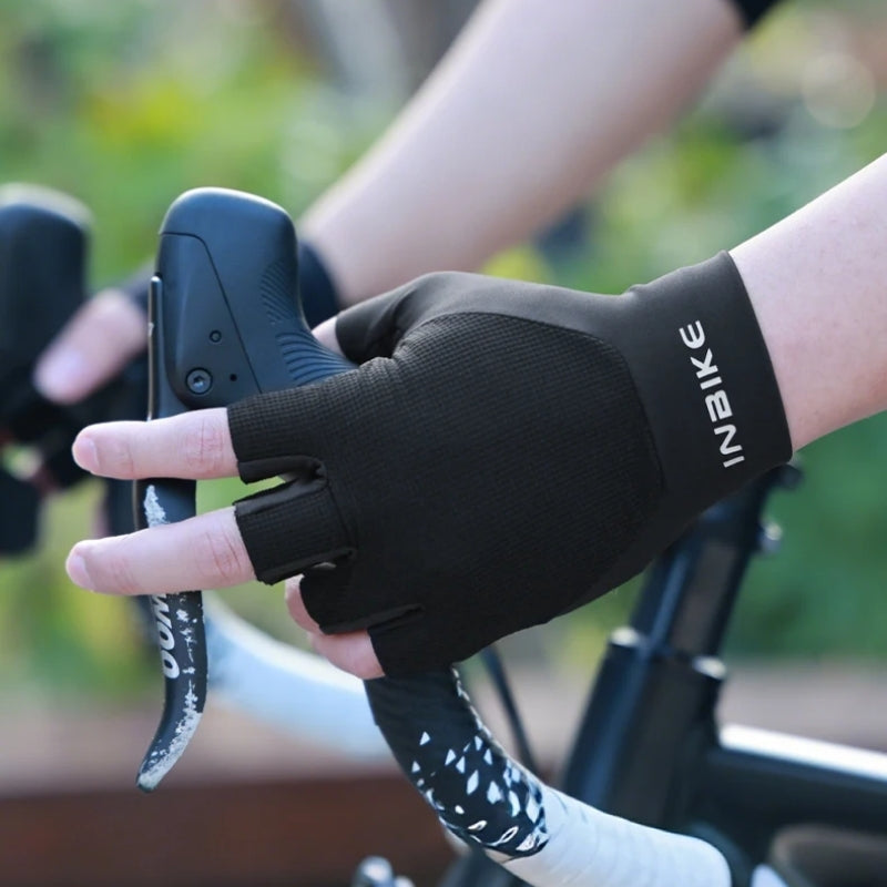 Person wearing a black cycling glove holding a bike handle.