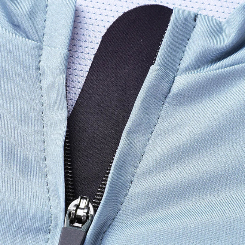 Close-up of a light blue zippered garment with a black zipper pull and a white mesh lining visible inside.