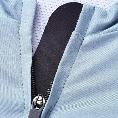 Close-up of a light blue zippered garment with a black zipper pull and a white mesh lining visible inside.