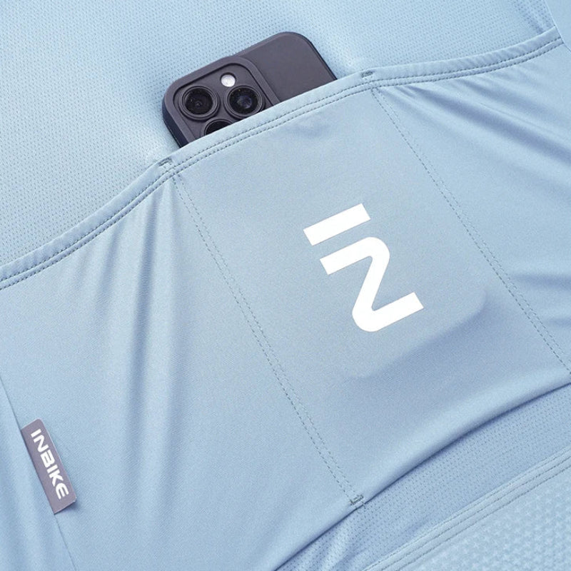 Close-up of a light blue athletic garment with a front pocket holding a dark smartphone. 
