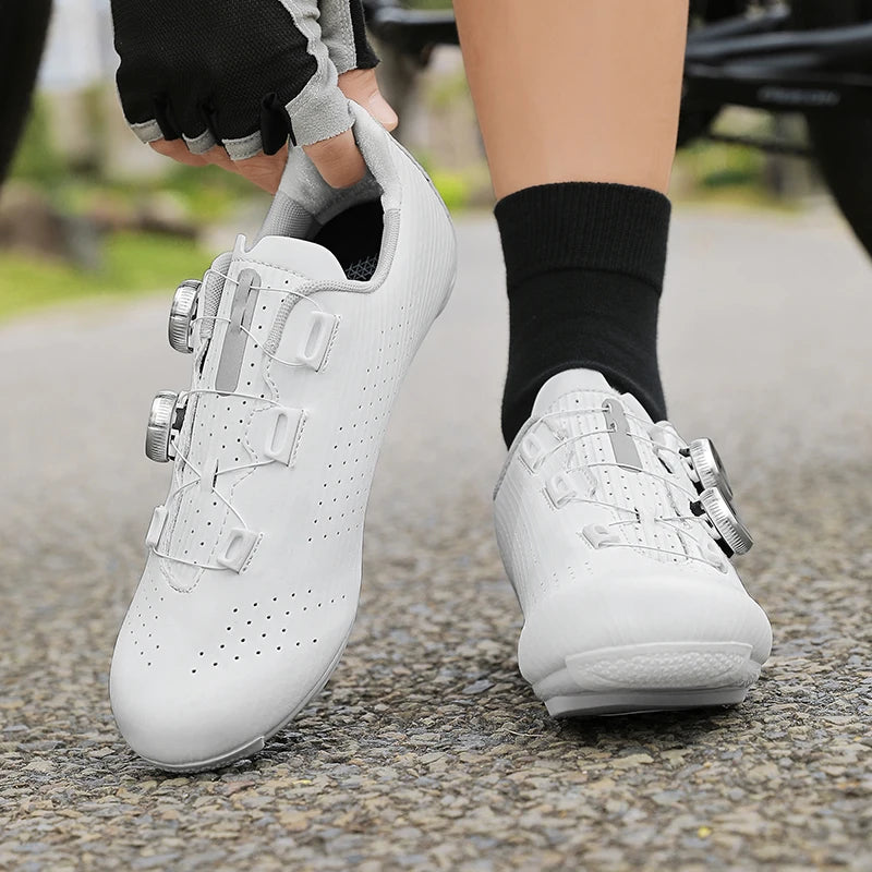 White cycling shoes being worn on a road with blurred background