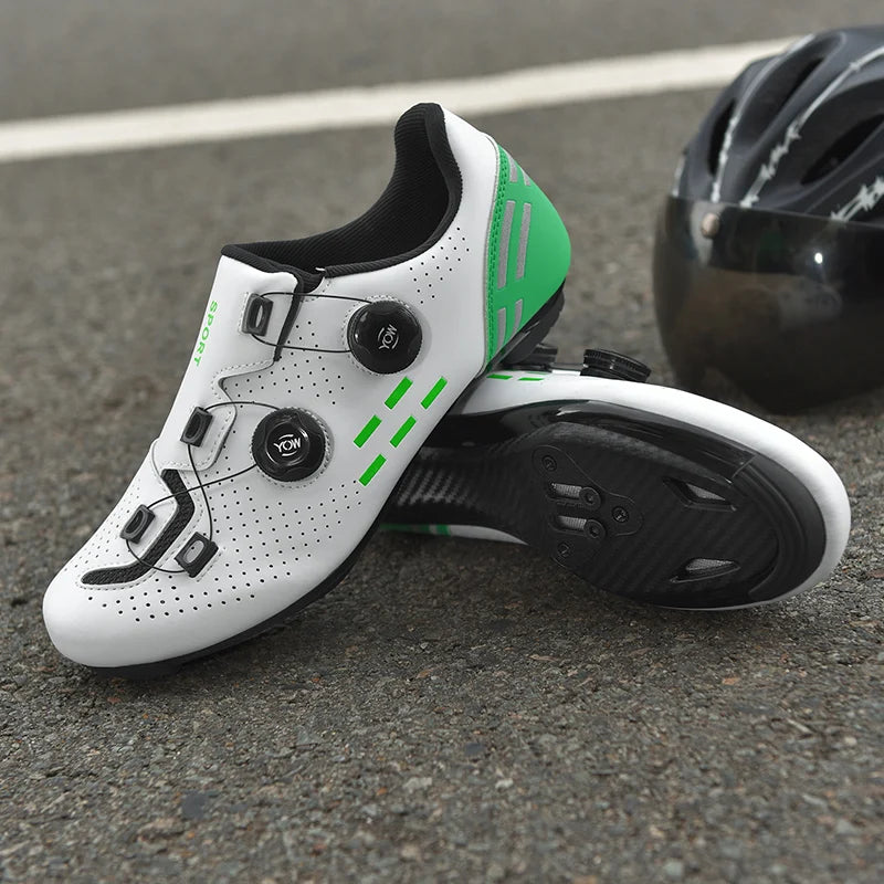 White cycling shoes with green accents and a black helmet on a road surface