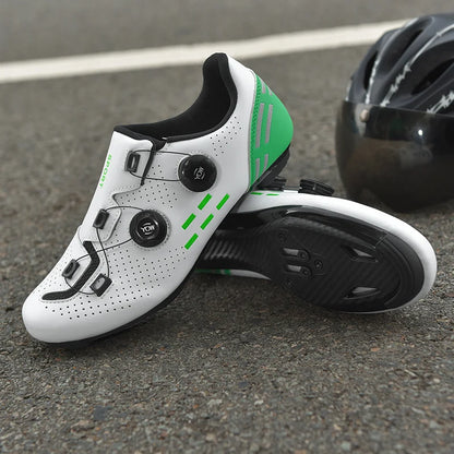 White cycling shoes with green accents and a black helmet on a road surface