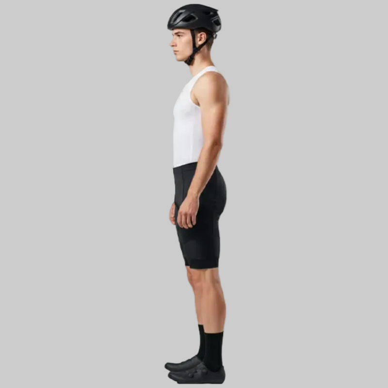 Person wearing a white sleeveless shirt, black cycling shorts, and a helmet on a gray background