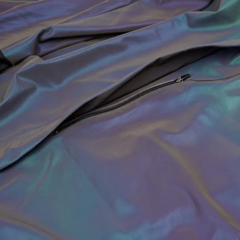 Close-up of a reflective, iridescent fabric with a zipper.