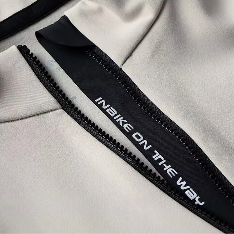 Close-up of a gray jacket with a black zipper and 'INBIKE ON THE WAY' branding.