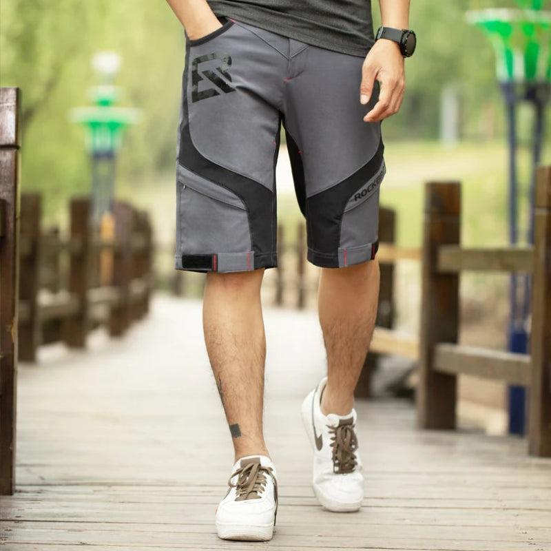 Person wearing gray shorts with black accents on a wooden deck