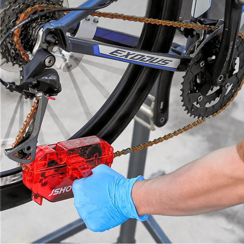 Person using a red bike chain tool on a bicycle 