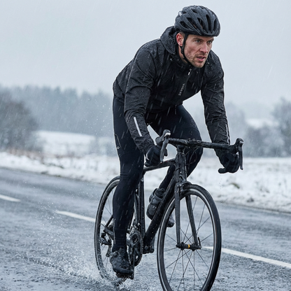 Man cycling on a snowy road wearing winter gear