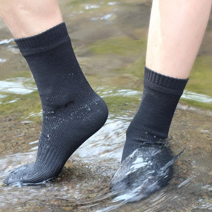 Person wearing black socks standing in water